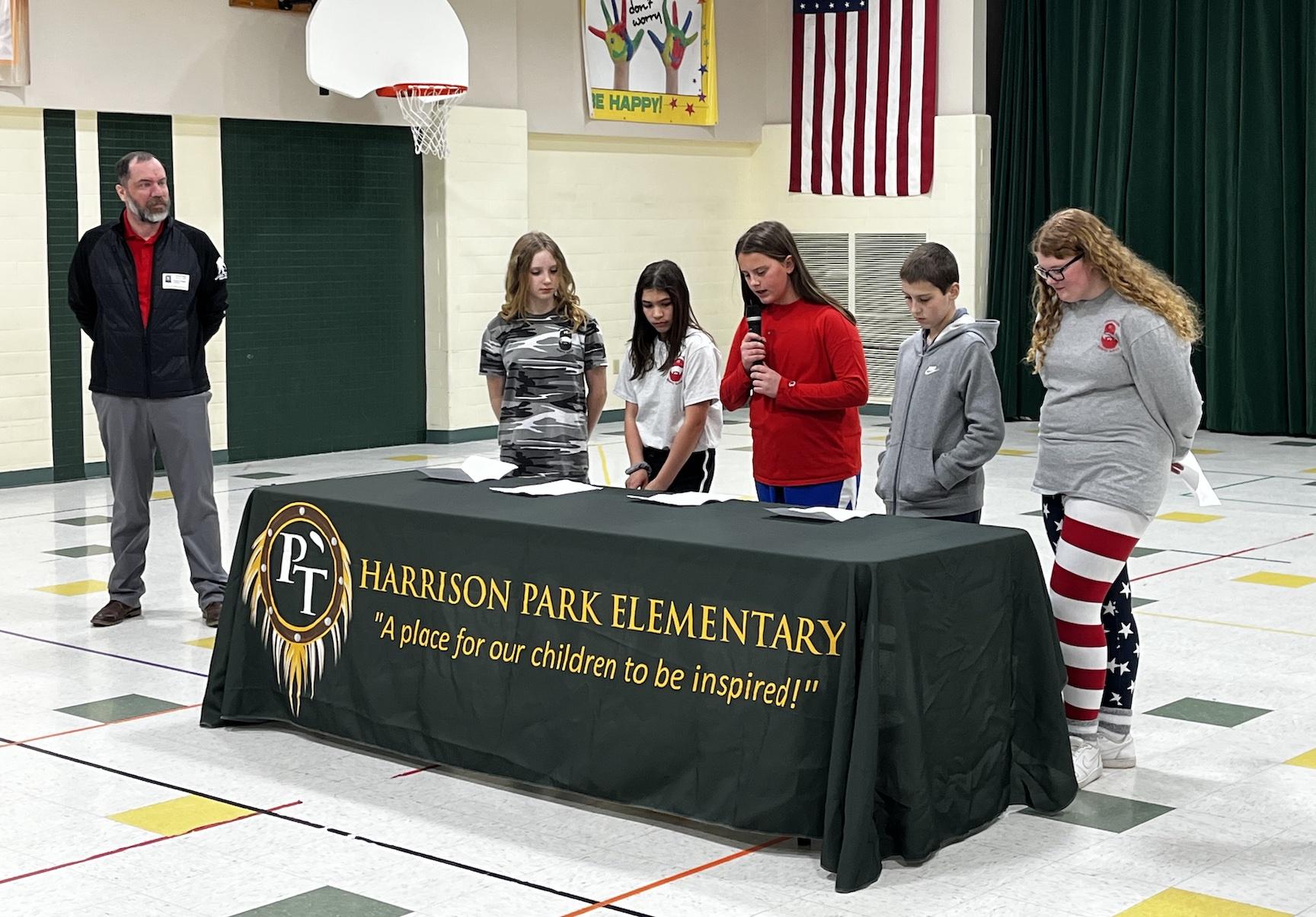 Wounded Warrior Representative Shawn Seguin listens to remarks by  5th-grade students Lauren Kain, Katelyn Speer, Samantha O’Hern, Owen Stewart, and Lydia Grant