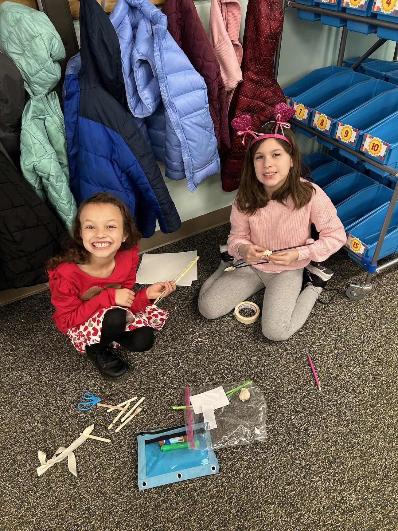 3rd-graders Tula DeFlavio and Caelyn Duddy work together to create a bow
