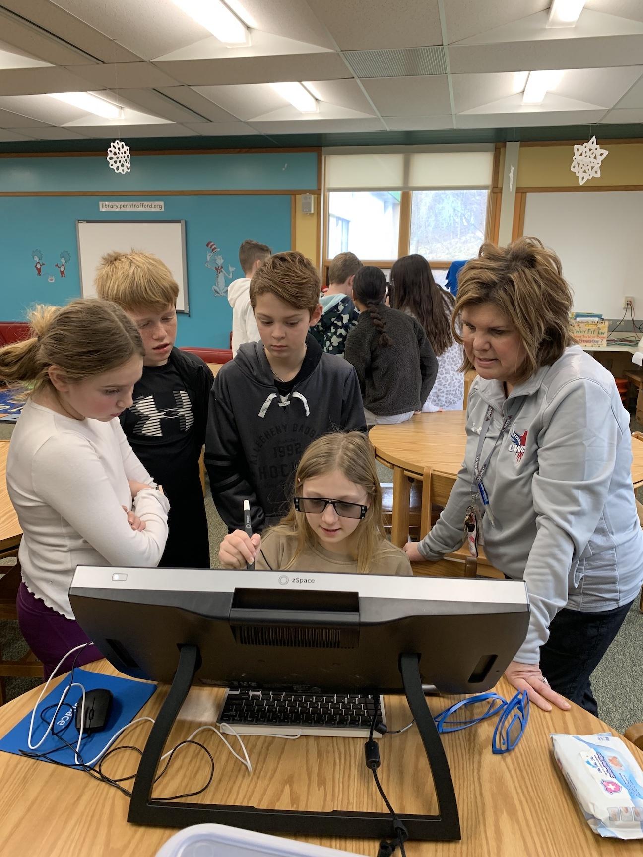 Harrison Park student, Natalie Sterner, overseen by CWCTC staff member, Darlene Patrick, uses the 3D computer zSpace while Ella Hileman, Dominic Capezzuto, and Chase Crawford watch