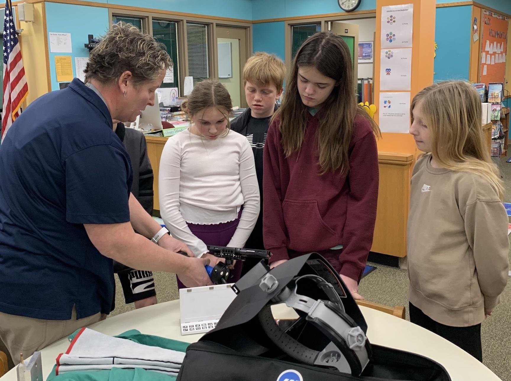 Michal Crist from CWCTC demonstrates the welding simulator to Harrison Park students, Ella Hileman, Dominic Capezzuto, Haydon Fitzgerald, and Natalie Sterner