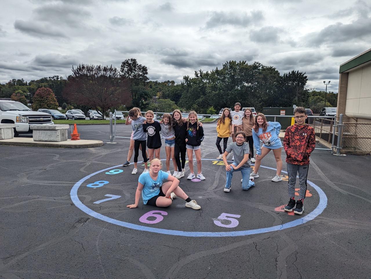 Fifth-graders gather at the completed clock mural